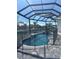 A serene pool area with a screened enclosure, stone pavers, and a tranquil canal view at 1426 Mineo Dr, Punta Gorda, FL 33950