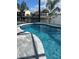 A beautiful pool with clear blue water, stone pavers, and a black safety fence at 1426 Mineo Dr, Punta Gorda, FL 33950