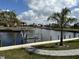 Scenic view of the waterfront with a canal, dock and boat lift, complemented by tropical palm trees at 1426 Mineo Dr, Punta Gorda, FL 33950
