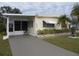 Light-yellow single-wide mobile home with a covered entryway and landscaped yard at 6405 Kilohee Ct, North Port, FL 34287