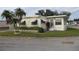 Attractive yellow mobile home with palm trees and well-maintained landscaping at 6405 Kilohee Ct, North Port, FL 34287