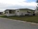 Side view of a single-wide mobile home showing a large window and AC unit at 6405 Kilohee Ct, North Port, FL 34287