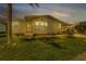 Tan single-story home with landscaped lawn and driveway at dusk at 648 Schooner St, North Port, FL 34287