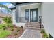 Steps leading to front door with glass panels and black railings at 280 Antis Dr, Rotonda West, FL 33947