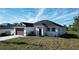 Single-story home with a two-car garage and well-maintained lawn at 26345 Trinilas Dr, Punta Gorda, FL 33983