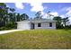 Charming single story home with a two car garage, set against a backdrop of lush trees and blue skies at 2163 Blaser St, Punta Gorda, FL 33980