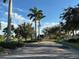 Community entrance with palm trees and a brick-paved road at 2736 Suncoast Lakes Blvd, Punta Gorda, FL 33980