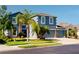 Two-story house with blue exterior, stone accents, and a three-car garage at 2736 Suncoast Lakes Blvd, Punta Gorda, FL 33980