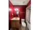 Bathroom with a toilet, sink, and red walls at 1405 Dorchester St, Port Charlotte, FL 33952