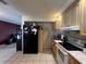 Kitchen with black fridge and light wood cabinets at 1405 Dorchester St, Port Charlotte, FL 33952