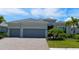 Gray two-story house with three car garage and landscaping at 25133 Longmeadow Dr, Punta Gorda, FL 33955