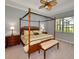 Main bedroom with four-poster bed, carpet flooring, and large windows at 25133 Longmeadow Dr, Punta Gorda, FL 33955