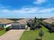 Aerial view of single Gathering home with manicured landscaping, three car garage, and tile roof at 15240 Spanish Point Dr, Port Charlotte, FL 33981