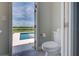 Small bathroom with toilet and sink; pool and water view visible through door at 15240 Spanish Point Dr, Port Charlotte, FL 33981