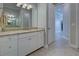 Bathroom vanity with granite countertops, white cabinetry, and a large mirror with decorative lighting at 15240 Spanish Point Dr, Port Charlotte, FL 33981