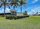 Harbor West community sign surrounded by lush landscaping on a sunny day at 15240 Spanish Point Dr, Port Charlotte, FL 33981