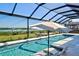 Enjoy this inviting pool with waterfront views, complete with an umbrella and chairs at 15240 Spanish Point Dr, Port Charlotte, FL 33981