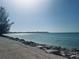 Scenic view of the Gulf with a rock seawall and clear blue sky at 15240 Spanish Point Dr, Port Charlotte, FL 33981