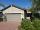 Single-story home with gray siding, two-car garage, and landscaped front yard at 2555 Brassica Dr, North Port, FL 34289