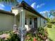 House entrance with stone pillars, a dark brown door and lush landscaping at 2555 Brassica Dr, North Port, FL 34289