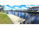 Waterfront dock with a ladder and views of canal and lush landscapes at 56 Colony Point Dr, Punta Gorda, FL 33950