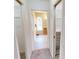 Hallway view leading to bathroom featuring tile flooring and views to the walk-in closets on both sides at 56 Colony Point Dr, Punta Gorda, FL 33950