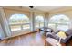 Bright living room featuring hardwood floors, large arched windows, and comfortable seating at 56 Colony Point Dr, Punta Gorda, FL 33950