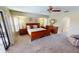 Bright main bedroom with plush carpet, a wooden sleigh bed, and large windows with plantation shutters at 56 Colony Point Dr, Punta Gorda, FL 33950