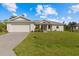 White single-story house with a two-car garage and a spacious lawn at 8136 Welsford Rd, Port Charlotte, FL 33981