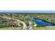 Community entrance with lush landscaping and lake at 3332 Grand Vista Ct # 101, Port Charlotte, FL 33953