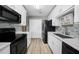 Modern kitchen features white cabinets, black appliances, and light wood floors at 3332 Grand Vista Ct # 101, Port Charlotte, FL 33953