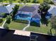 Aerial view of the home’s backyard, screened pool, and private dock access to a canal at 9310 Rosebud Cir, Port Charlotte, FL 33981