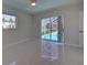 Bright bedroom with marble floors, ceiling fan, and sliding glass doors to the pool at 9310 Rosebud Cir, Port Charlotte, FL 33981