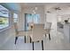 This dining area features a modern glass table, seating for four, and picturesque views of the backyard pool at 9310 Rosebud Cir, Port Charlotte, FL 33981