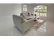 Bright, airy living room featuring modern neutral furniture and sleek marble flooring at 9310 Rosebud Cir, Port Charlotte, FL 33981
