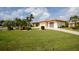 Landscaped front yard with lush lawn and tropical plants at 442 Macedonia Dr, Punta Gorda, FL 33950