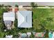 An aerial view of a home with a metal roof, swimming pool, and green landscaping at 611 W Olympia Ave, Punta Gorda, FL 33950