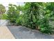 Gravel backyard with a brick border and lush tropical foliage along the fence line at 611 W Olympia Ave, Punta Gorda, FL 33950