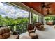 Screened-in balcony with wicker furniture and a view of lush greenery at 611 W Olympia Ave, Punta Gorda, FL 33950