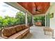 Large screened-in balcony with wood ceiling and wicker furniture at 611 W Olympia Ave, Punta Gorda, FL 33950