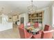 Dining room features a glass table with seating for six, custom built-in shelving, with easy access to the kitchen at 611 W Olympia Ave, Punta Gorda, FL 33950
