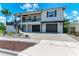 Two-story home with a two-car garage, front porch, and beautiful landscaping at 611 W Olympia Ave, Punta Gorda, FL 33950