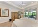 Bright main bedroom featuring tray ceiling, ceiling fan and light hardwood floors with access to screened outdoor patio at 611 W Olympia Ave, Punta Gorda, FL 33950