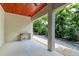 Covered patio featuring a wood ceiling, white columns, and a view of the lush backyard at 611 W Olympia Ave, Punta Gorda, FL 33950