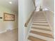 Beautiful staircase with wood treads, white risers, and detailed artwork on the adjacent wall at 611 W Olympia Ave, Punta Gorda, FL 33950