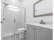 Bright bathroom with a white vanity, patterned floor, and a glass-enclosed shower with white tiled walls at 13454 Ingraham Blvd, Port Charlotte, FL 33981