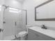 Modern bathroom featuring glass shower door, gray vanity, and decorative tiled floor at 13454 Ingraham Blvd, Port Charlotte, FL 33981