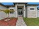 Inviting home exterior featuring a stone-accented facade, double-door entry, and landscaped front yard at 13454 Ingraham Blvd, Port Charlotte, FL 33981