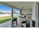 Outdoor kitchen and seating area with a grill, ceiling fans, and view of the green yard at 13454 Ingraham Blvd, Port Charlotte, FL 33981