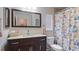 Clean bathroom with a floral shower curtain and a dark vanity at 2556 Saturday St, North Port, FL 34288